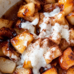 Air Fryer Apples: A Quick and Healthy Treat for Busy Parents 2 Golden caramelized air fryer apple slices with cinnamon and brown sugar, served in a white bowl with a drizzle of caramel sauce