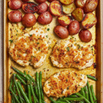 Parmesan Crusted Chicken - A Simple and Delicious Recipe for Beginners 2 Golden brown parmesan crusted chicken breast with crispy cheese coating, sliced to show juicy interior, served on a white plate with lemon wedges